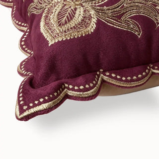Close-up of the maroon velvet cushion corner showing the scalloped gold embroidery.