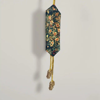 Close-up shot of the Rustic Flora Tassel hanging, detailing the geometric tapestry panel and the fuzzy gold cord.