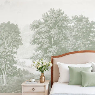 A luxury bedroom featuring the Saanjh sage forest mural behind a bed with sage green velvet cushions.