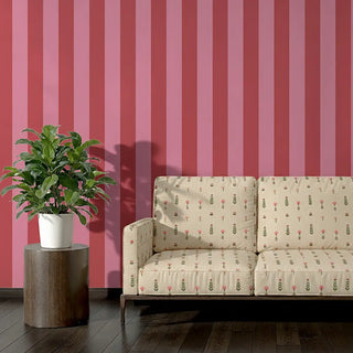 Sofa upholstered in Saanjh Fabric featuring tiny floral sprigs against striped wallpaper.