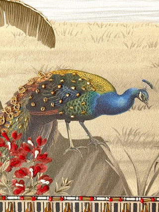A detailed macro close-up of the Safar embroidered wall art showing a peacock with gold beads, gold thread coils and red knotted floral stitches.