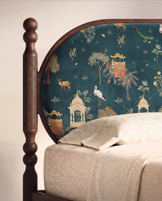 A luxury master bedroom featuring a curved wooden headboard upholstered in Sair Blue velvet.