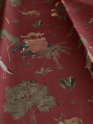 A draped view of the Sair Red fabric showing the soft textile texture and rhythmic heritage pattern of elephants and trees.
