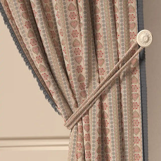 A close-up of the Sarangi Fringes curtain tied back with a tasseled cord, highlighting the gathered fabric and the textured fringe.