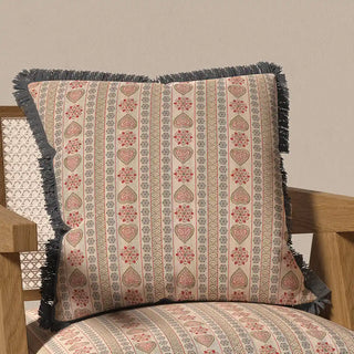 The Sarangi Fringes cushion cover displayed on a chair, showcasing its unique bohemian and textured look in a home decor setting.