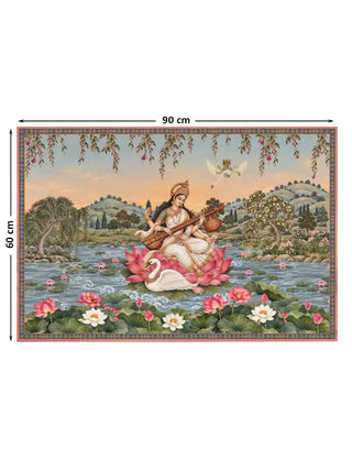 The Saraswati Maa wall art, medium size 60 by 90 centimetres, showing Saraswati seated on a lotus playing the veena beside a swan, amid a lotus pond and pastoral landscape.