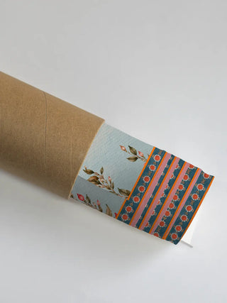 A rolled print of the Saraswati Maa wall art showing coordinating border segments with a rose-branch motif and a striped floral band in pink, orange and teal.
