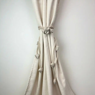Sculpted Petal Handcrafted Curtain Holdback cinched on a cream curtain, showcasing the soft texture and subtle neutral color palette.