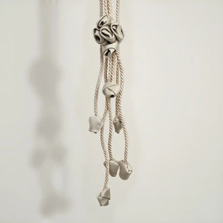 Close-up shot of the Sculpted Petal Tassel hanging, detailing the central fabric rosette and the various cascading fabric bud charms.