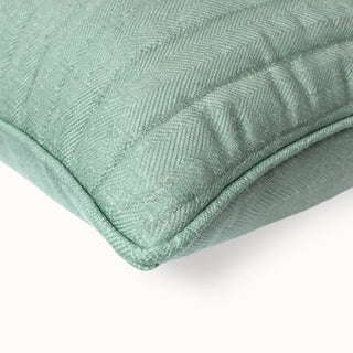 Close-up of the light blue cushion corner showing the navy fringed wave strip.