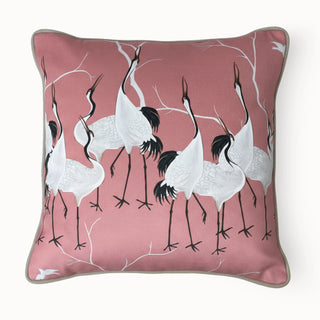 Full studio view of the Sedge Cushion featuring the crane bird pattern on a pink base.