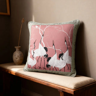 Single Sedge Serene Cranes Cushion displayed on a beige sofa against a dark wall.