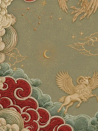 Close-up texture of gold embroidered constellations, a crescent moon and a winged ram against a sage-green ground, showing the fine stitch detail of the Seraphim design
