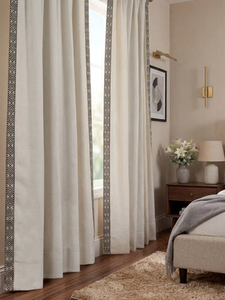A pair of Serene Strokes curtains framing a window in a modern neutral bedroom with mid-century furniture.
