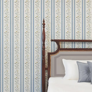 Blue & beige floral stripe wallpaper styled behind a wooden bed with neutral bedding, giving a fresh and soft backdrop.