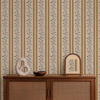 Mustard & beige floral stripe wallpaper styled behind a rattan console with decorative accents.