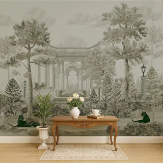 A pastel green vintage wallpaper featuring classical arches, tall palm trees, and black panthers, styled behind a wooden console with floral decor.