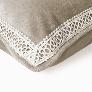Close-up of the taupe velvet cushion corner showing the intricate white lace trim.