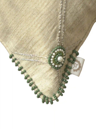 A high-resolution close-up of the silver lattice lines, green glass seed bead rosettes, pearl center, and beaded edging on the corner of the Shahzar cushion cover.