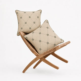 Two Shahzar cushion covers on a rattan folding chair, sage medallions on a beige diamond trellis