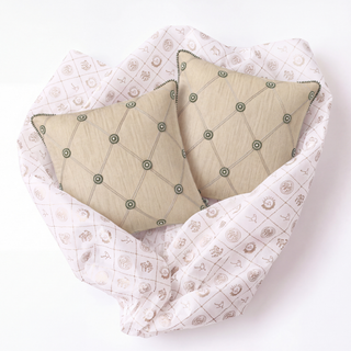 Shahzar quilted pillows styled on pink quilted bedding featuring celestial and garden motifs, showcasing the complementary pattern contrast and layered design.