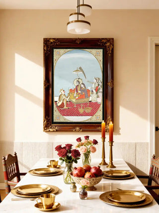 Shri Ram Parivar wall art in an ornate rosewood and gilt frame above a marble dining table set with brass plates, roses, pomegranates and brass candlesticks in a warm dining room