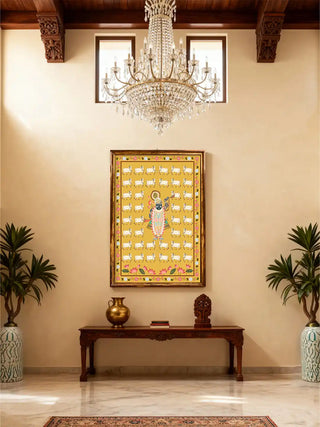 Large Shrinathji Pichwai poster displayed on a high-ceiling beige wall in a luxury foyer with a chandelier.