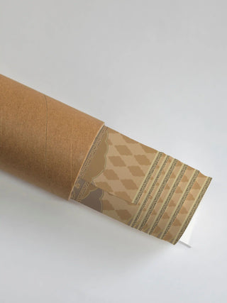 The Shyam Sundar wall art rolled in a kraft cardboard tube, with the beige cloud-lattice and geometric border showing at the open end.