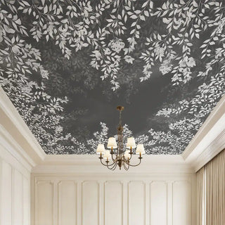 A luxury room featuring the Silent Orchard deep charcoal ceiling mural styled with a classic tiered chandelier and neutral walls.
