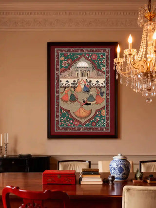 Framed Sorena wall art in emerald rouge on a panelled wall beside a crystal chandelier, above a polished dining table set with a blue and white ginger jar.