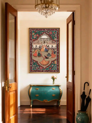 Framed Sorena wall art in emerald rouge above a teal and gilt bombé chest, seen through open doors in a sunlit entryway.