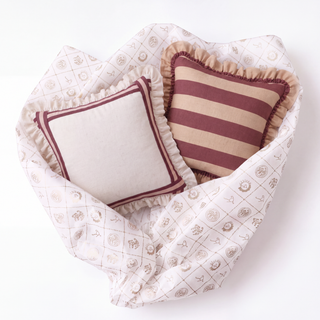 Spellbound Cinnamon pillows styled on pink quilted bedding with celestial motifs, showcasing the complementary color palette and layered romantic design.
