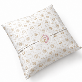 Angled view of single coordinating celestial-quilted pillow in ivory with gold motifs and hand-painted rose-gold sun seal to complete the set.