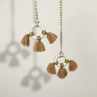 Close-up shot of the Springhaven Holdback hanging, highlighting the texture of the macrame-wrapped rings and the braided cord.