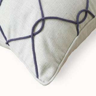 A close-up detail of the Stallion cushion showing the ivory herringbone linen texture and the raised purple cord trellis.