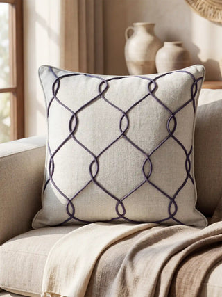 A lifestyle view of the Stallion cushion styled on a beige sofa next to rustic ceramic vases.