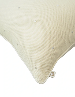A high-resolution close-up of the raw ivory linen canvas grid weave and hand-stitched silver glass bugle beads on the Stardust cushion cover.