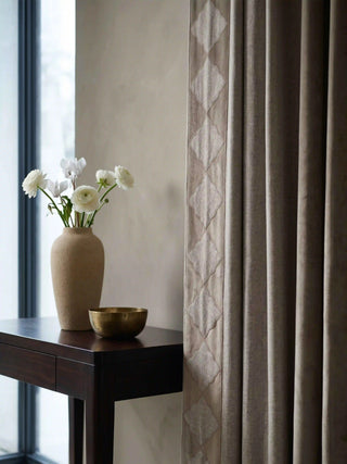 A high-resolution close-up of the premium taupe linen-blend fabric weave and soft drapery folds of the Storah curtain.