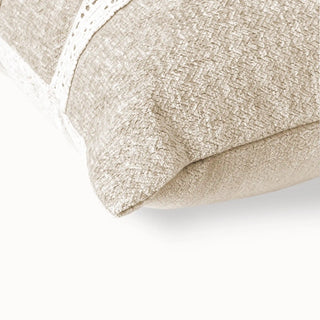 Close-up of the beige cushion corner showing the textured fabric and lace trim.