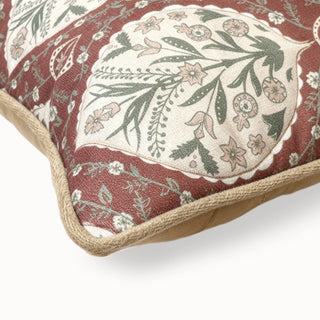 Close-up of the maroon printed cushion corner showing the floral motif and piping.