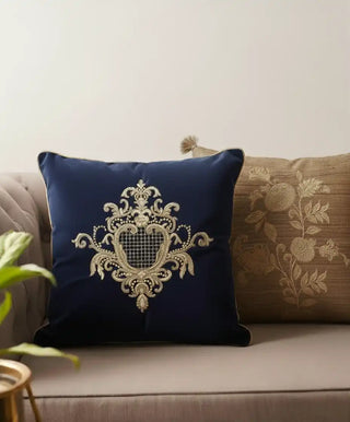 Navy blue cushion with intricate white embroidery on a beige couch. buy cushion covers from suneherii collection.