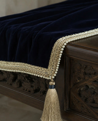 The Syahi sofa throw in Navy, view-detail of the gold braided pearl-edged trim and silk tassel.