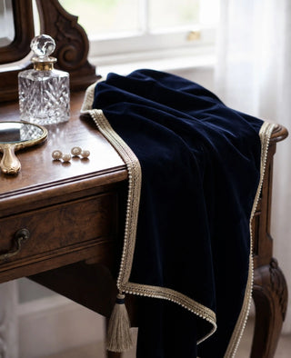 The Syahi sofa throw in Navy, view-dressingtable beside a crystal decanter and pearl earrings.