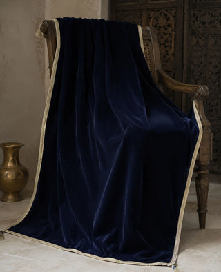 The Syahi sofa throw in Navy, view-heritagebench beside a brass vase and carved screen.