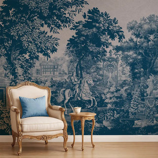 A blue European tapestry-style wallpaper depicting a scenic landscape with trees, architectural elements, and a horse rider, styled behind a vintage armchair.