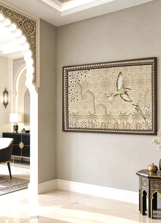The Birds of Anqa embroidered wall art framed on a wall beside a carved archway and black marble side table.