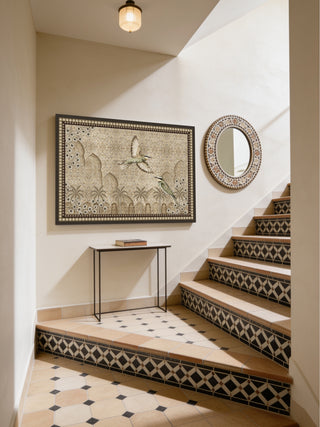 The Birds of Anqa custom framed wall art print installed beautifully within a Mediterranean-style staircase landing layout next to a mosaic circular mirror.