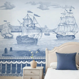 The Blue Horizon Mural Wallpaper: Full wall installation of the blue and white scenic sailing ships mural behind a bed.