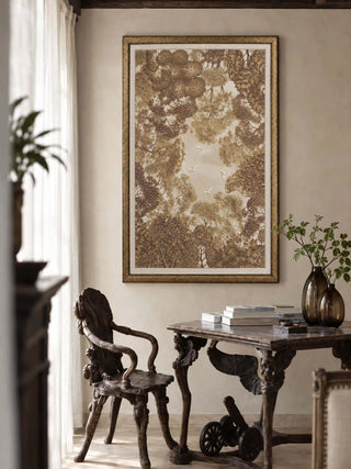The Forest Nest embroidered wall art framed above a carved wooden table and armchair beside a curtained window.