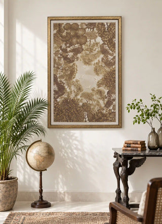 The Forest Nest embroidered wall art framed above a marble-top console beside a vintage globe and a potted palm in a sunlit living room.